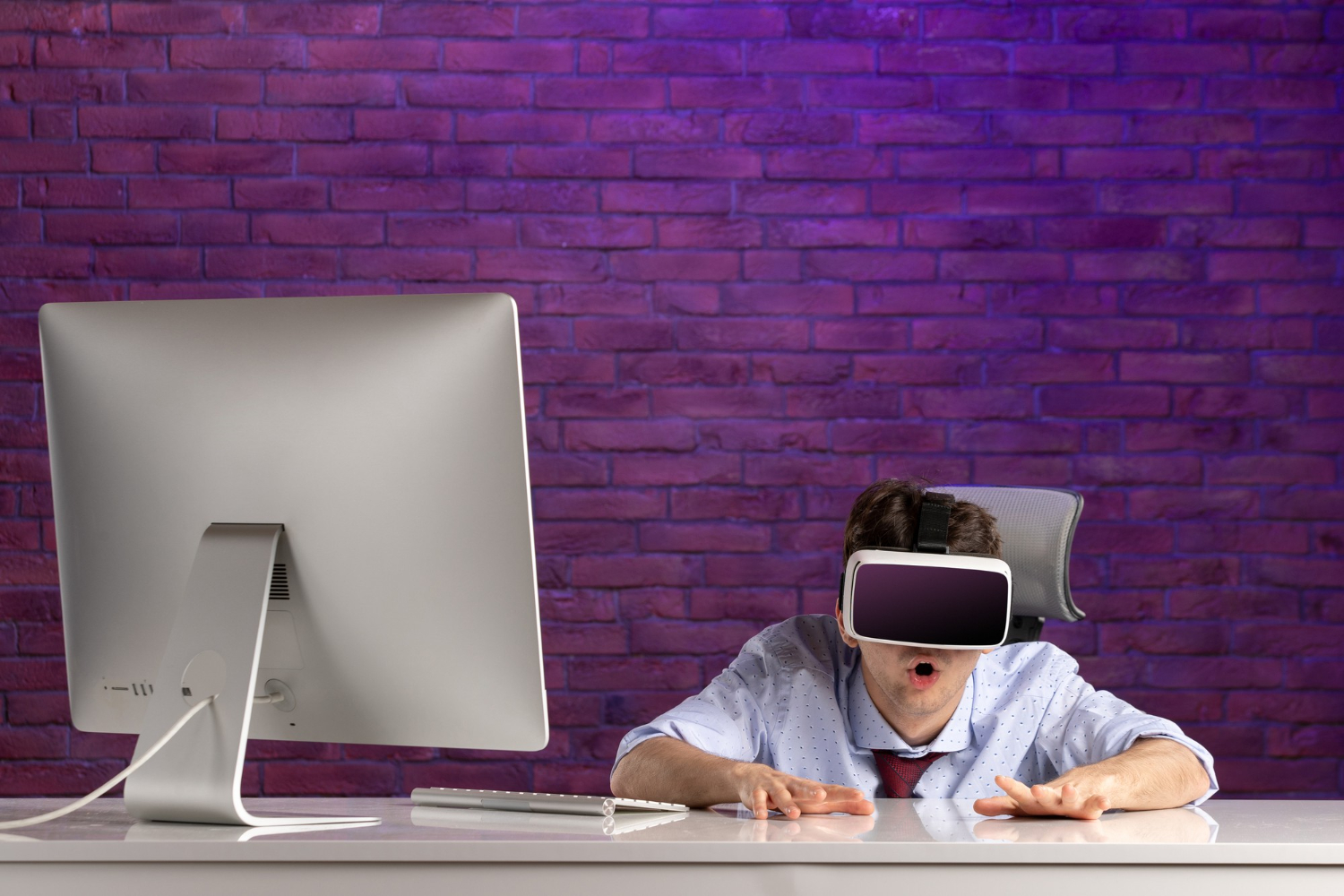 Person sitting in front of a computer wearing VR