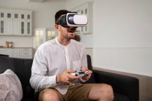 A person wearing a virtual reality headset sits on a couch, holding a game controller, immersed in gaming within a modern living room.