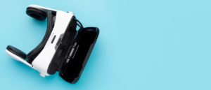 A white VR headset positioned on a light blue background, partially opened revealing a black compartment underneath.