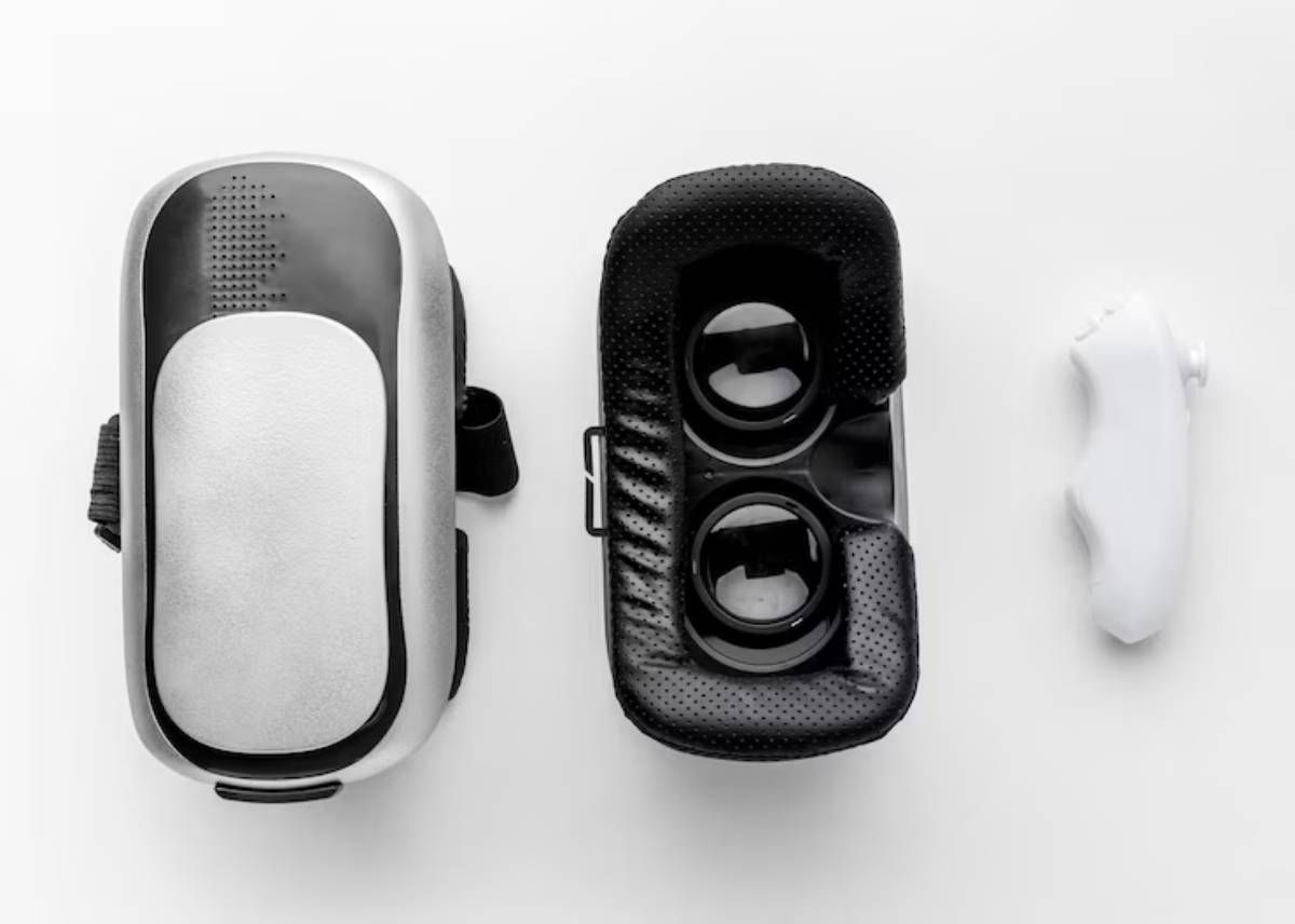 A sleek black VR headset with eyepieces beside a compact white remote control, all displayed on a light background.