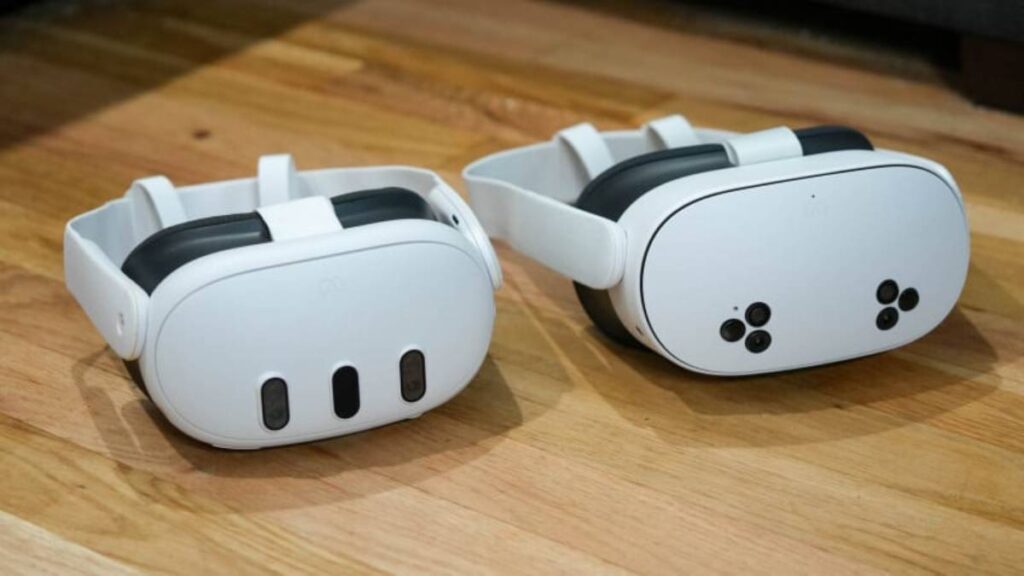 Two white virtual reality headsets with black padding resting on a wooden floor, showcasing distinct designs and sensor placements.