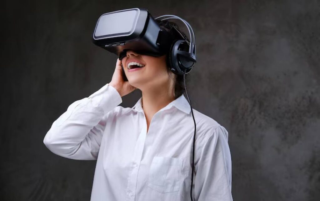A person wearing a VR headset and headphones stands against a textured gray background, engaged in a virtual experience.