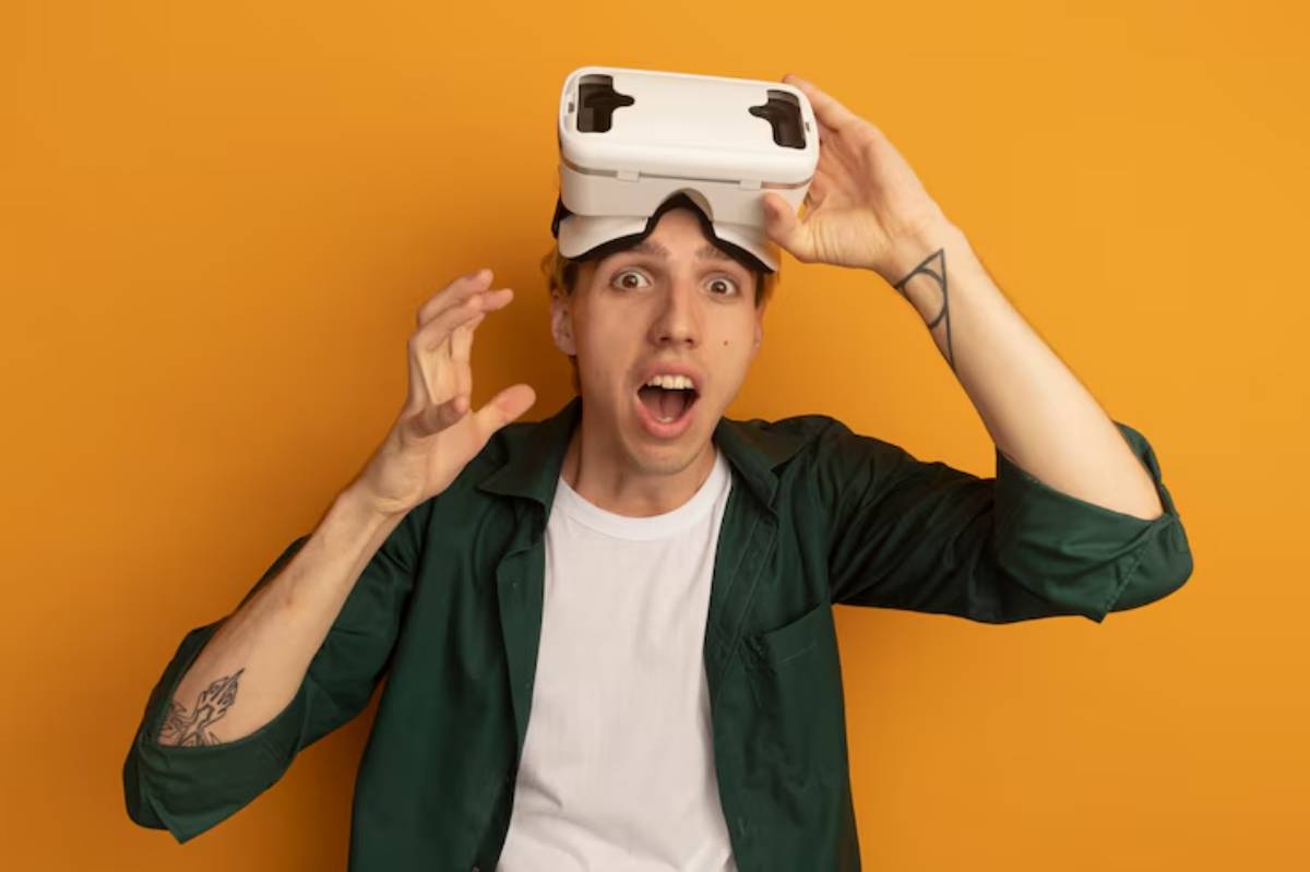 A person wearing a virtual reality headset, with hands raised as if interacting with virtual elements, against a vibrant orange background.