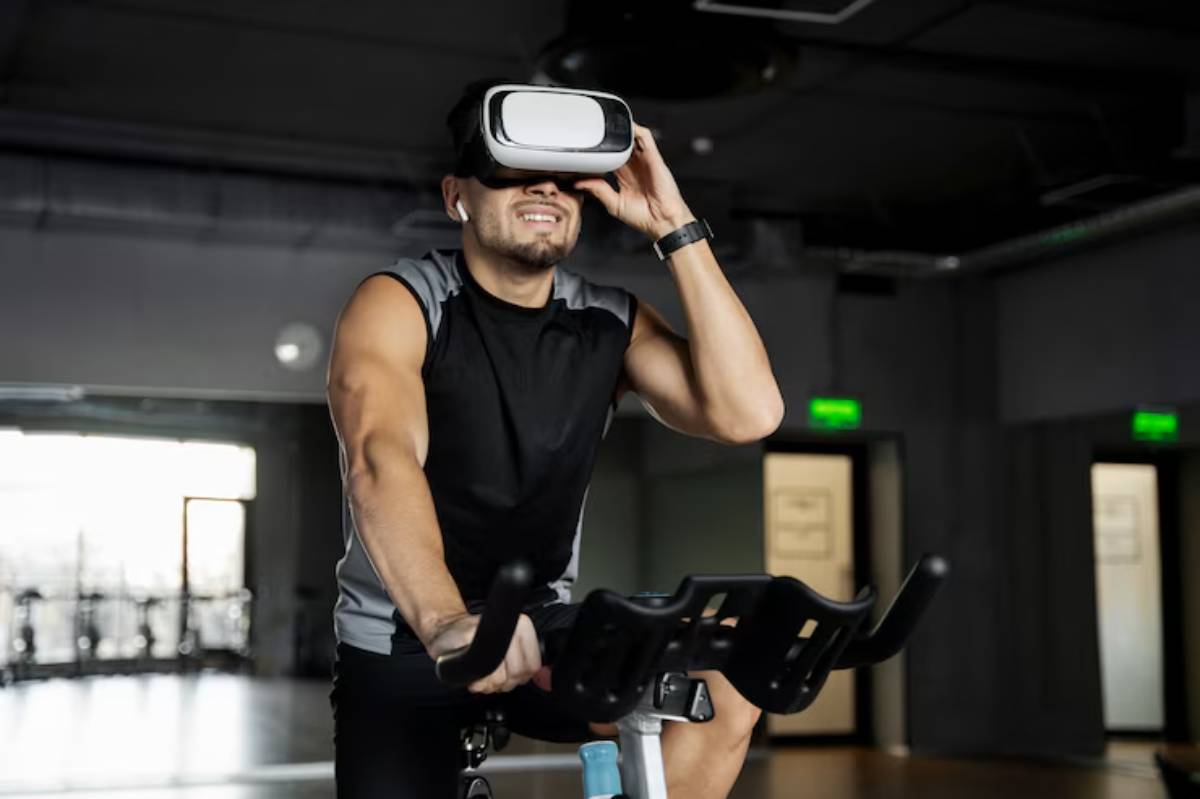 A person in a gym cycling on a stationary bike while wearing virtual reality goggles, focused on their workout experience.