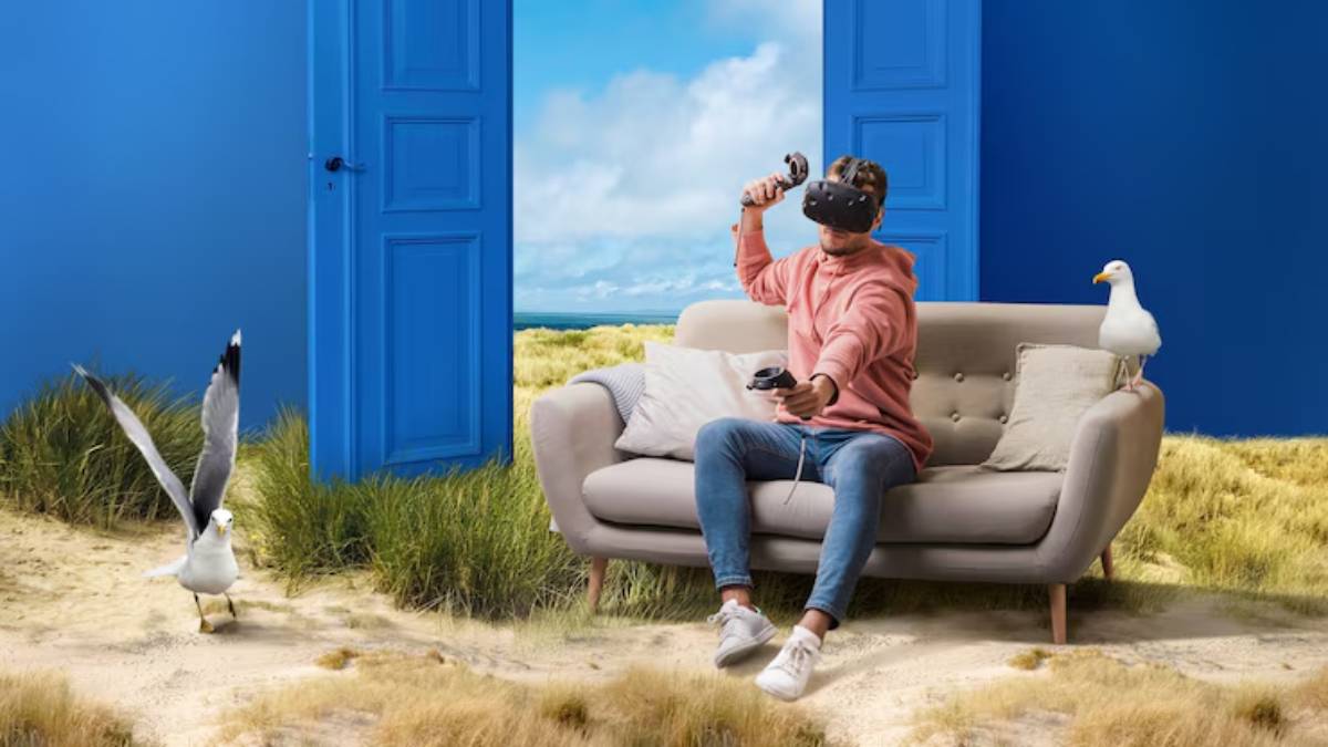 A person in a VR headset sits on a sofa in a surreal setting with a blue door, seagulls, and a grassy landscape behind them.