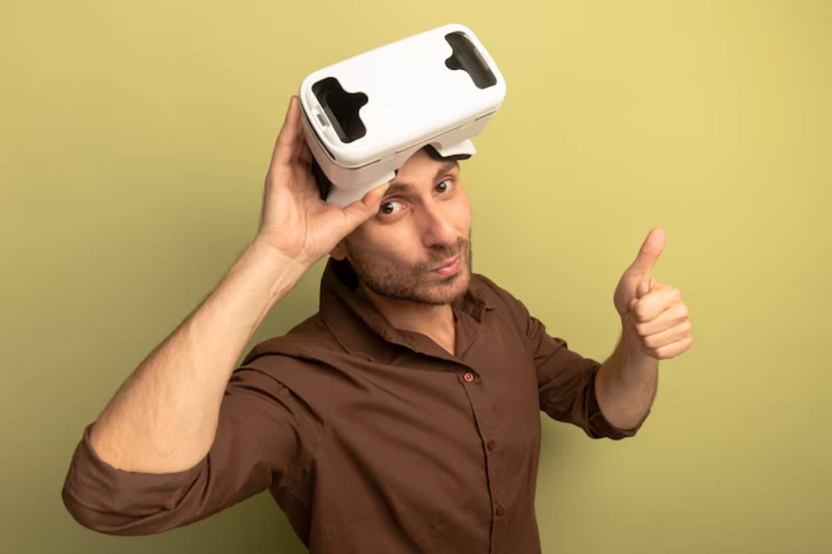 A person wearing a virtual reality headset gives a thumbs up against a green background, showcasing excitement for the experience.