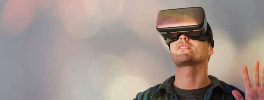 A person wearing a virtual reality headset raises their hand, immersed in a digital experience against a blurred, colorful background.