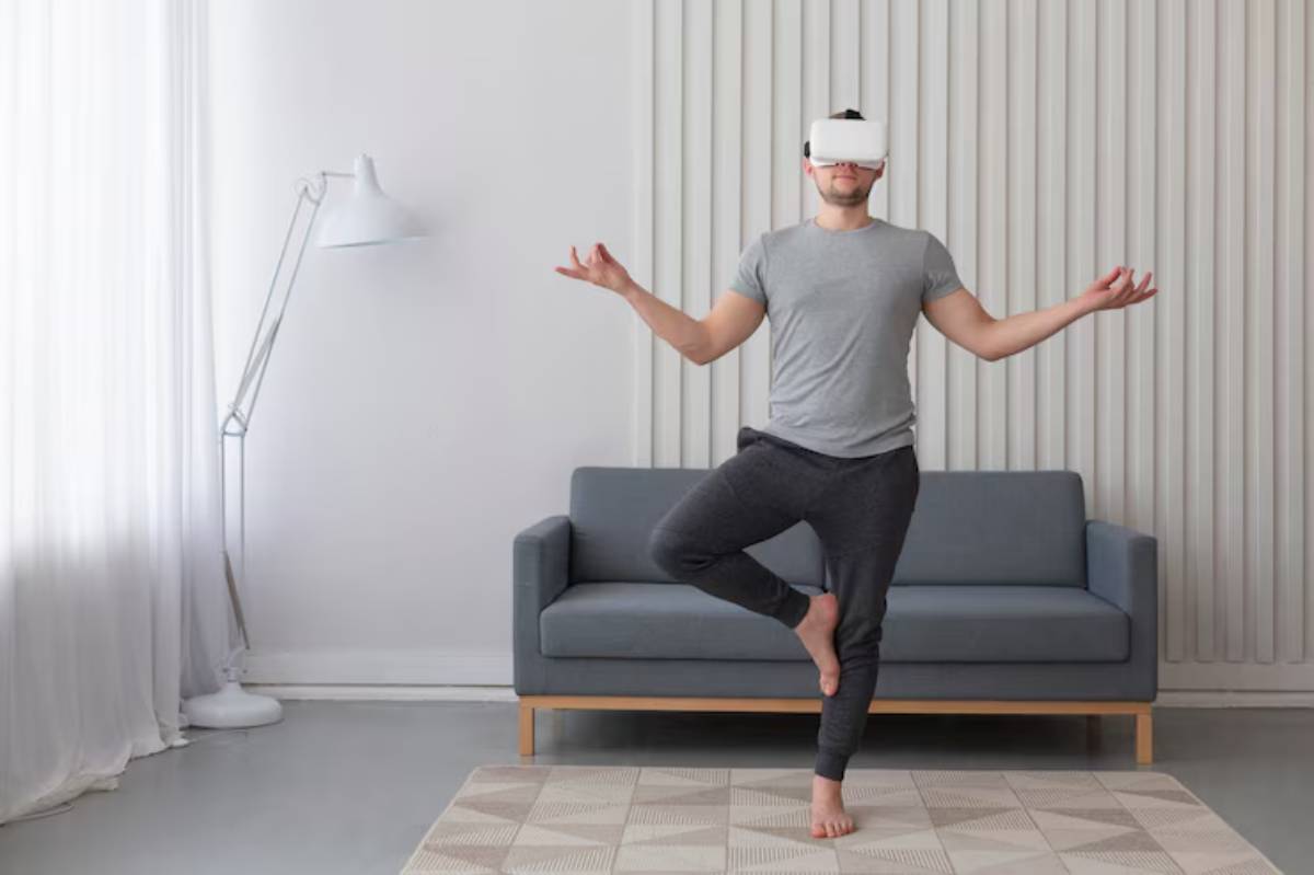 A person stands in a yoga pose on one leg in a modern living room, wearing a virtual reality headset. A gray couch and lamp are visible.