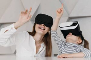 A child wearing a virtual reality headset excitedly raises a hand, while an adult shares a moment of engagement beside them.