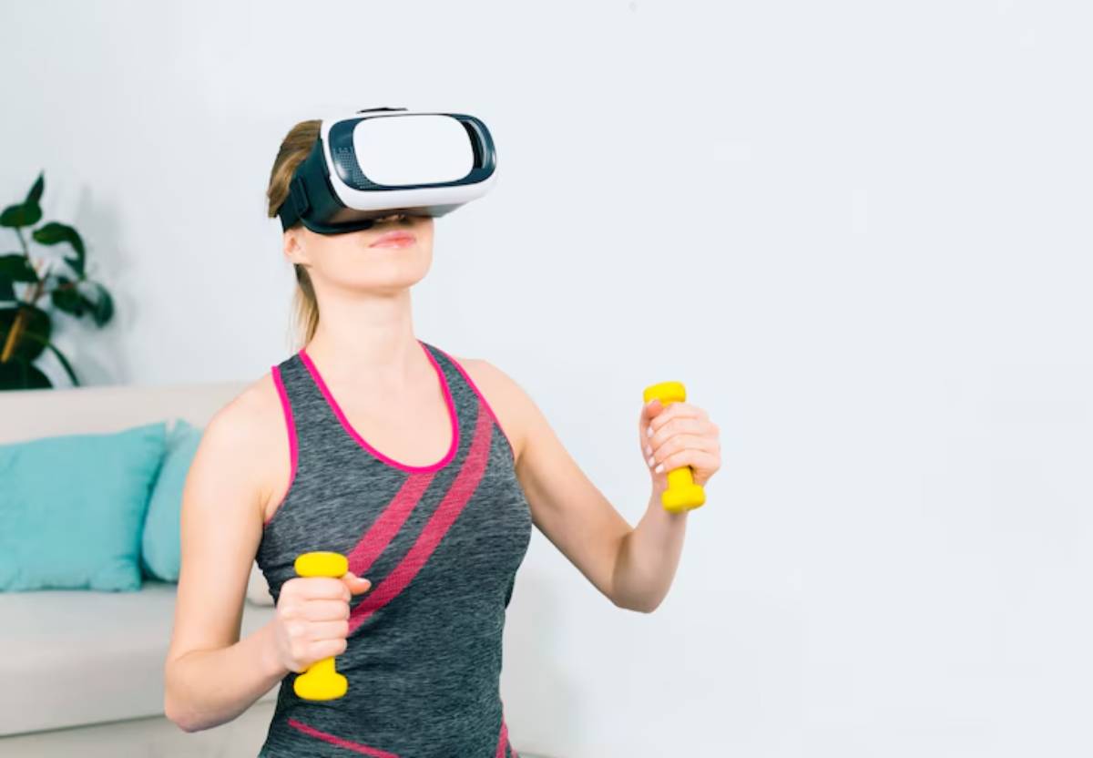 A woman in a fitness outfit holds yellow dumbbells while wearing a virtual reality headset, engaged in an active workout at home.