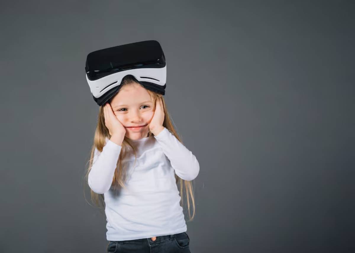 A child wearing a virtual reality headset stands against a grey background, appearing engaged and curious about the virtual environment.